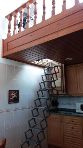 a kitchen with a spiral staircase in a kitchen at Country House Alfarim in Alfarim