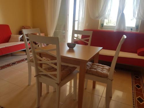 a dining room with a table and four chairs at App LOLLY in Selce