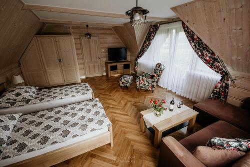 ein Wohnzimmer mit einem Bett und einem Tisch in der Unterkunft Nocleg Pod Gubałówką in Nowe Bystre