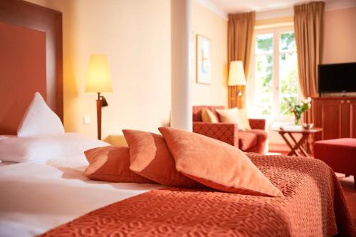 a hotel room with a bed with pillows on it at ROEWERS Privathotel & Spa in Ostseebad Sellin