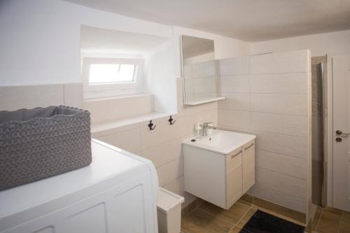 a white bathroom with a sink and a mirror at Spartion Marine in Split