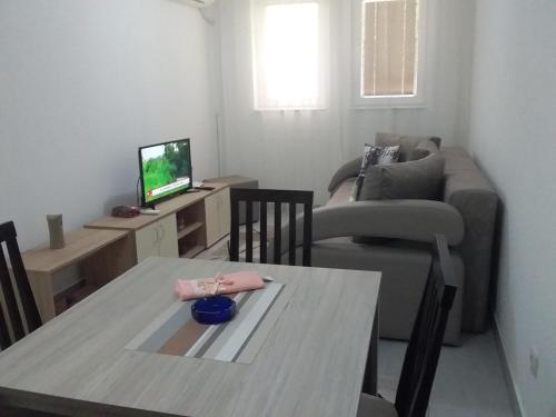 uma sala de estar com uma mesa e um sofá em Apartman Jevtić 1 em Gornja Toplica