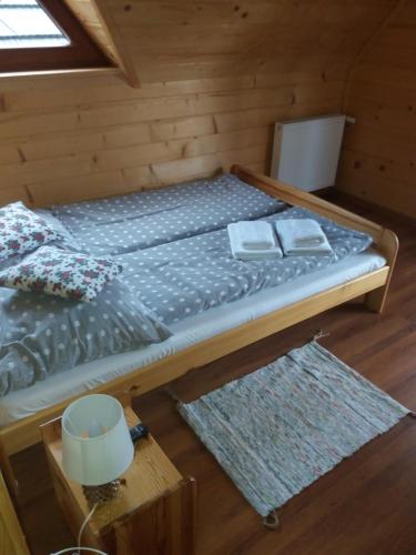 a bed in a cabin with two towels on it at Sebahouse in Zakopane