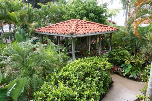 a gazebo with a red roof in a garden at Tropical Villas Of Venice Beach in Venice