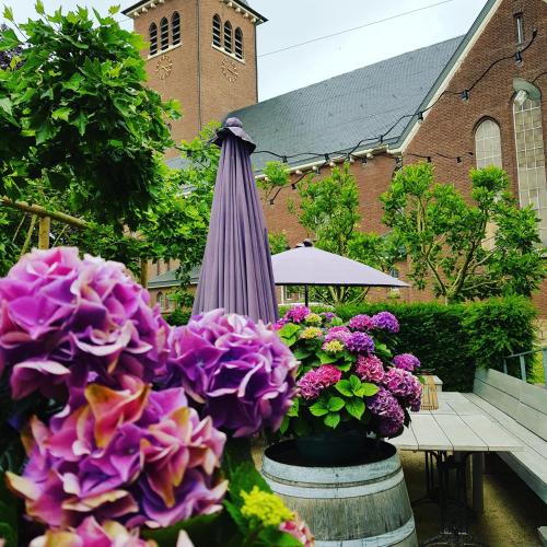 an umbrella and flowers in front of a church at Hotel Au Nom De Dieu in Dilsen-Stokkem