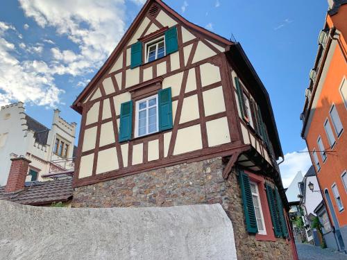 un edificio con ventanas verdes y blancas. en Fewo Zum Malerwinkel - Rüdesheim en Rüdesheim am Rhein