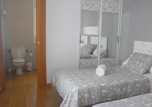 una camera con due letti e uno specchio di Be happy Arco ad Algodonales
