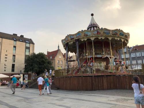 a group of people walking around a carousel at Moon River Apartments Gdansk Old Town in Gdańsk