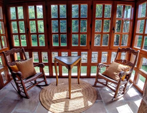 two chairs and a table in a room with windows at Trisileja en Novales in Novales