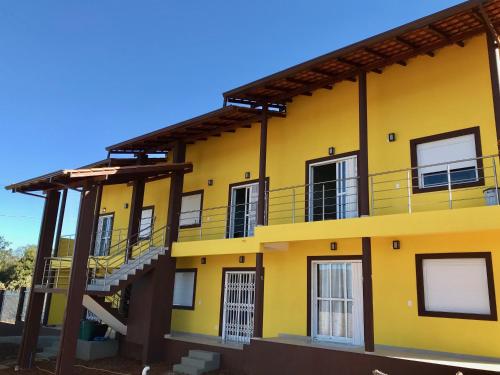 um edifício amarelo com escadas ao lado em Vila dos Cristais em Alto Paraíso de Goiás
