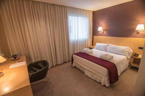 a hotel room with a bed and a desk at Salto Hotel y Casino in Salto