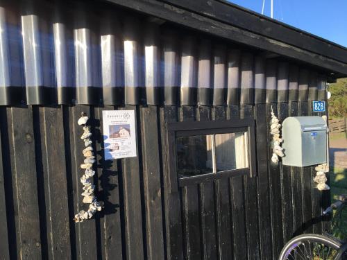 a black building with a door and a mailbox at Casablanca Hostel, hyggelig overnatning in Anholt