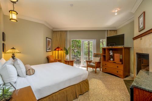 1 dormitorio con 1 cama grande y TV en Avila Village Inn en Avila Beach