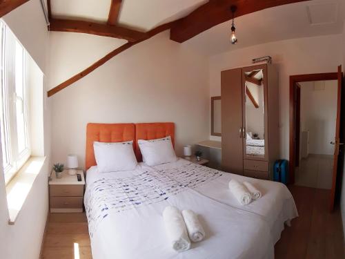 um quarto com uma grande cama branca com almofadas brancas em Liliana Bol Apartment with Wonderful Sea View Near the Beaches em Bol