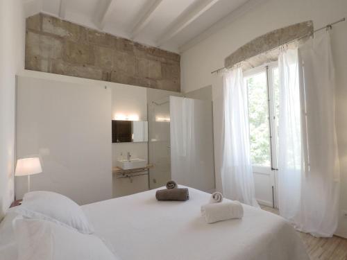 ein weißes Schlafzimmer mit einem Bett mit zwei Handtüchern darauf in der Unterkunft Orient Capdepera - Turismo de Interior in Capdepera
