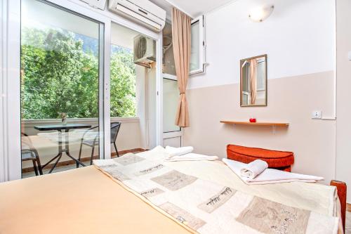 una habitación con una cama y una mesa y una ventana en Apartments Villa Popovic, en Kotor