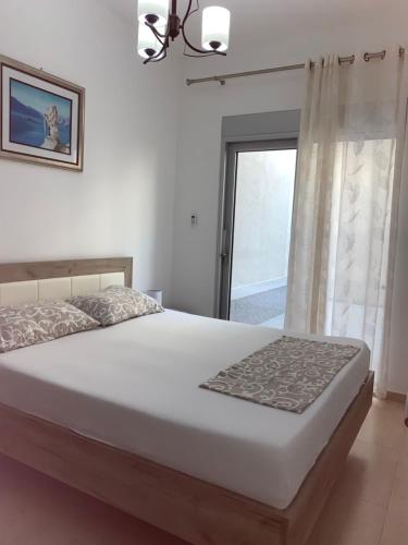 a bedroom with a large white bed with a window at Minka in Kotor