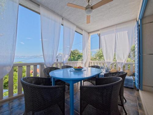 Villa Petra Sea View Island Brac في بوستيرا: غرفة طعام مع طاولة وكراسي زرقاء