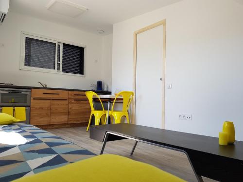uma sala de estar com uma mesa e cadeiras amarelas em Angers Green Lodge - Yellow Sun Appartement em Angers