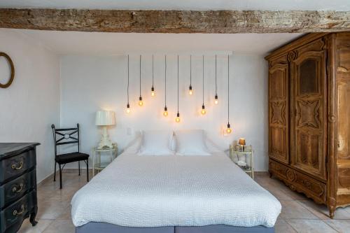 a bedroom with a large white bed and a chair at Maison Carles BnB in La Colle-sur-Loup