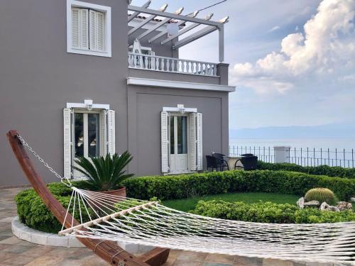 eine Hängematte vor einem Haus in der Unterkunft Villa Dolphin Akrata in Akráta