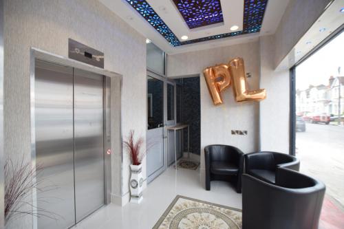 a lobby with a chair and a sign that says ego at PremierLux Serviced Apartments in Ilford
