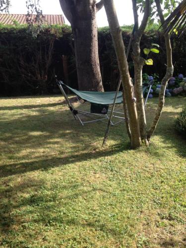 a hammock sitting next to a tree in a yard at Chez Uli in Angresse