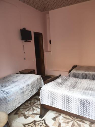 a room with two beds and a tv on the wall at Tatev Shinuhayr Hotel' in Shinuhayr