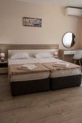 a bedroom with a large bed and a mirror at Margis Home in Burgas