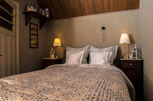 a bedroom with a bed with pillows and two lamps at B&B Tspijker in Mol