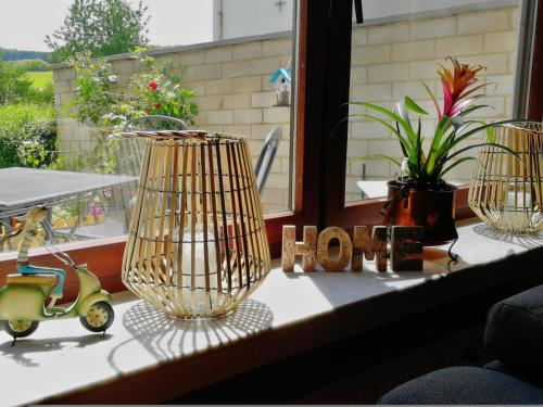 a window sill with a bird cage and a vase at Eifel Ferienhaus Luna in Ohlenhard