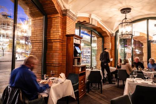 a group of people sitting at tables in a restaurant at Le Capitole Hotel in Quebec City