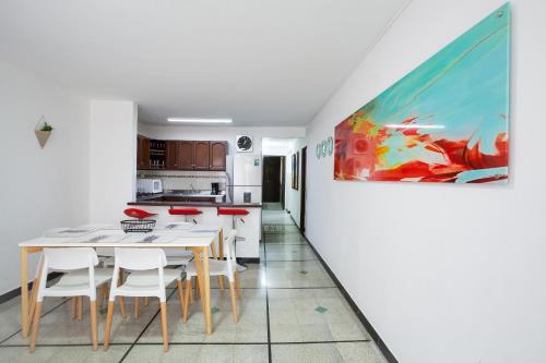 cocina y comedor con una pintura en la pared en Apartamentos Amoblados JG de la 70, en Medellín