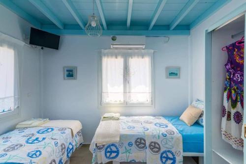 a blue room with two beds and a window at BLUE PARADISE SUITES in Pachaina