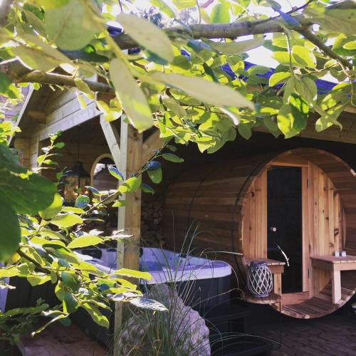 a wooden cabin with a bed in a tree at Château Martin in Esneux
