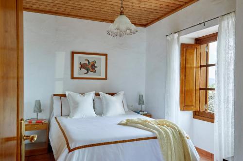 Un dormitorio con una cama blanca y una ventana. en Villa Nueva, en Mala