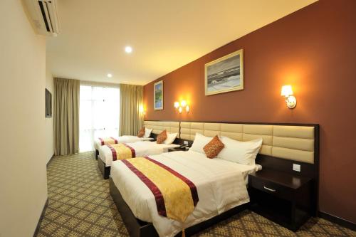 una habitación de hotel con 2 camas en una habitación en Hallmark Regency Hotel - Johor Bahru, en Johor Bahru