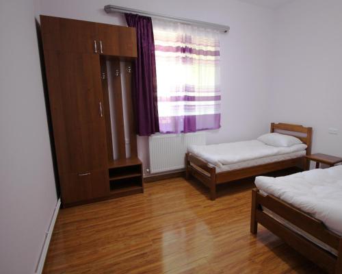 a room with two beds and a cabinet and a window at Karin's B&B in Sisian