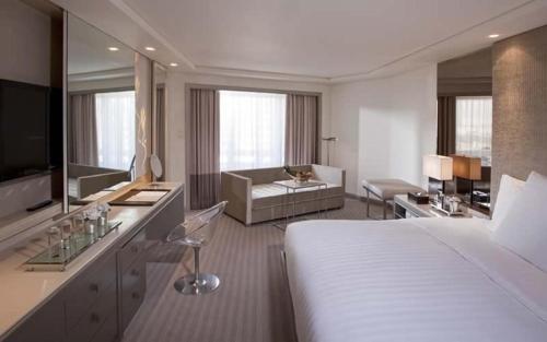 a hotel room with a bed and a living room at Midas Hotel and Casino in Manila