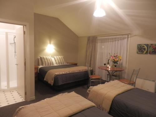 a hotel room with two beds and a table at Lake Wanaka Lodge in Wanaka