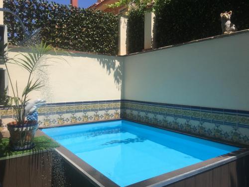 a swimming pool in a backyard with a tile wall at Apartment with private patio in Fuengirola