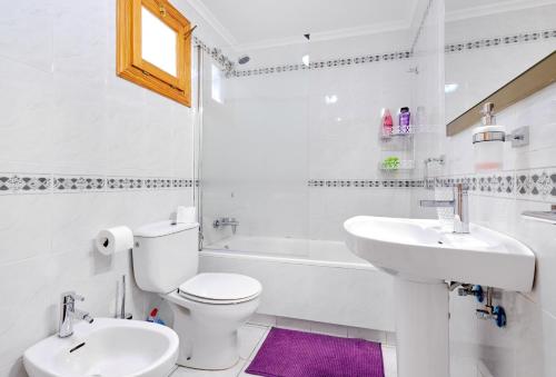 a white bathroom with a toilet and a sink at urb ViñaMar in Torrevieja