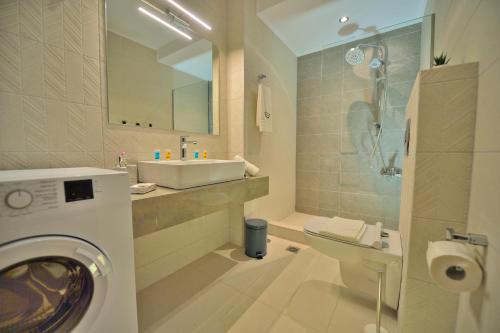 uma casa de banho com um lavatório e uma máquina de lavar roupa em Aristea Apartments em Palaiochora