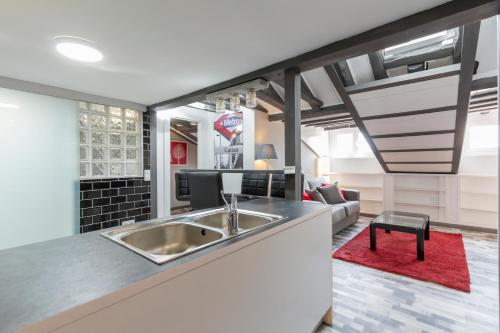 a kitchen with a sink and a living room at Luna Apartment in Madrid