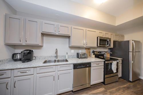 a kitchen with white cabinets and a stainless steel refrigerator at Mint House Nashville - Hillsboro Village in Nashville