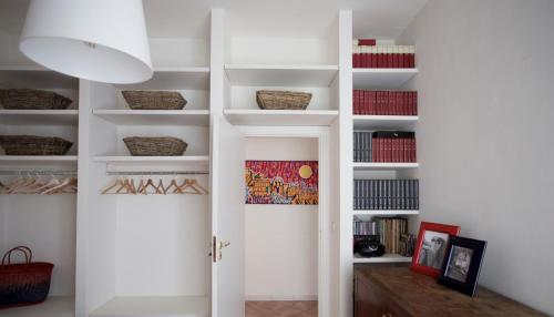 a hallway with white shelves and a door at Maison Gioffredi in Ischia