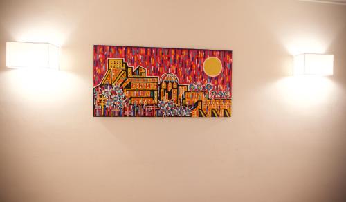 two lights on a wall with a painting on it at Maison Gioffredi in Ischia