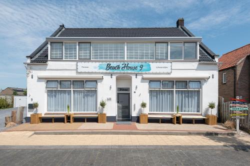 um edifício branco com um cartaz que lê as melhores drogas em Beach House 9 em Scharendijke