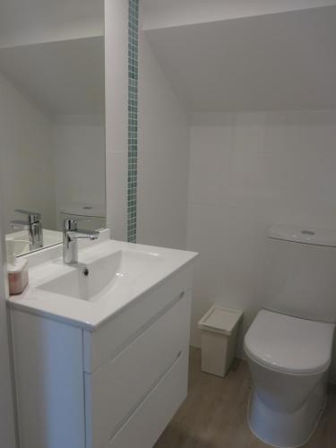 a white bathroom with a sink and a toilet at SERENA BEACH 3 in Nazaré