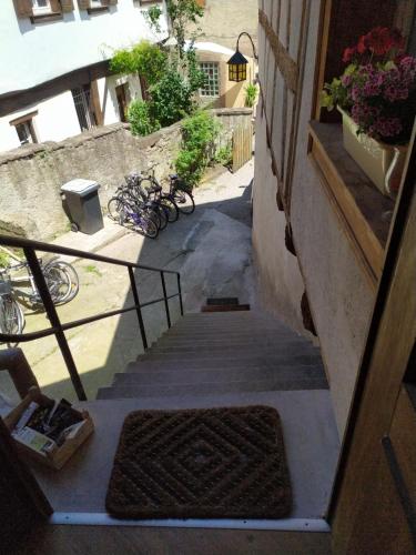 a stairway leading up to a building with a rug at La Grande Terrine - Gîtes Les Potiers in Kaysersberg